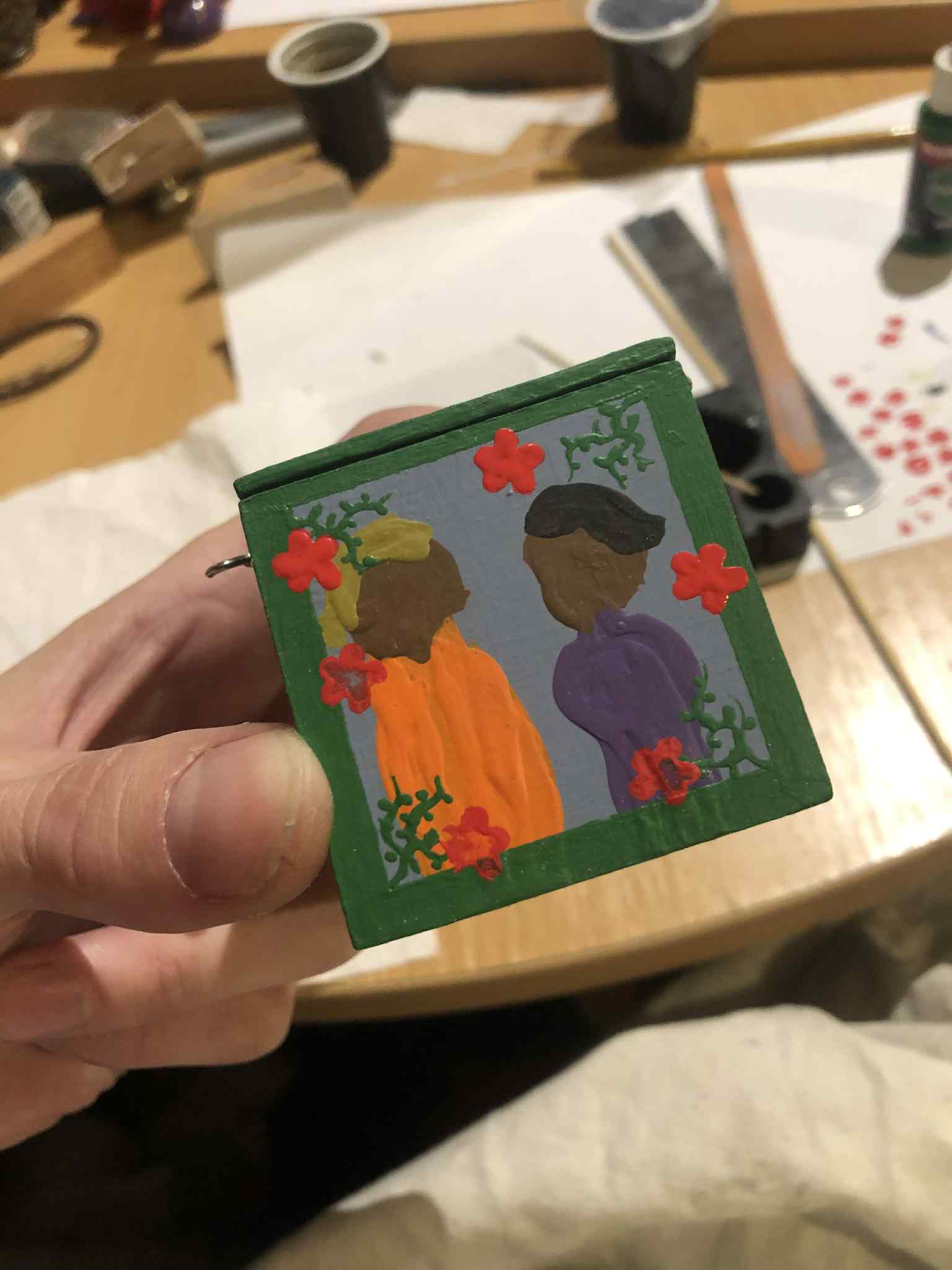 The red flowers starting to be painted over a second time. Initially the paint was quite sparse, in that the red paint wasn't in the middle of the flowers nearly as much. In this photo, half of the flowers on one of the sides were painted over a second time to fill them in fully, using the initial stamp as a template for where to paint, and the others to be done were still a lot less vibrant, and you could see the paint quite clearly behind the red.