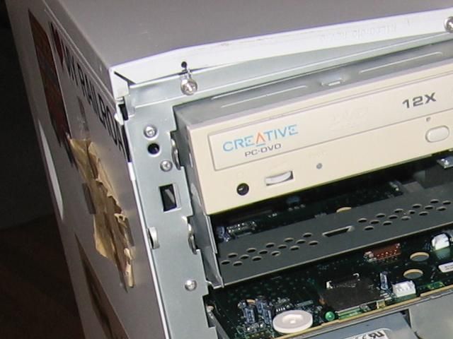 A closeup of the computer, with the face removed. The outer casing is bent away from the corner.