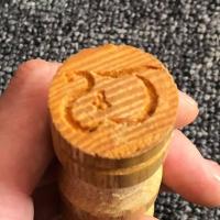 A wooden Metroid carved into a dowel