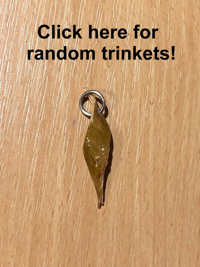 A fun twist of bark, now coated in varnish and with a metal ring attached through a hole near the top of it, with the text click here for random trinkets!