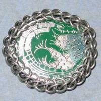 A coin with a crocodile on it, wrapped in chainmaille