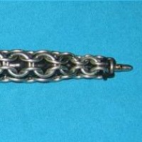 A tight chainmaille weave over a pen tube, on a teal background