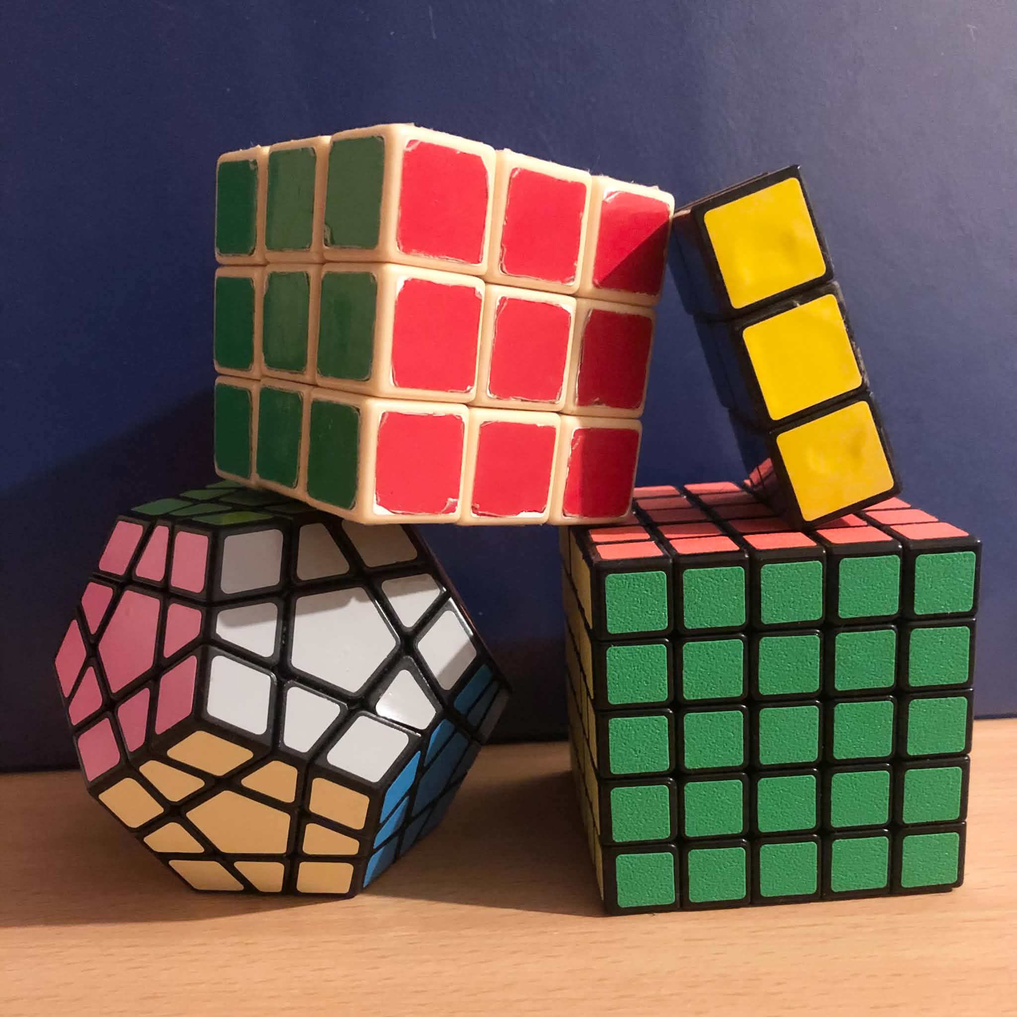 Four Rubik's cube type twisty puzzles stacked together.