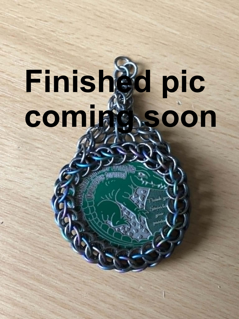 The pic of the wrapped coin with hanger attached, with text over it saying finished pic coming soon.