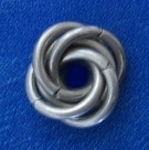 A chainmaille mobius ball ona blue surface
