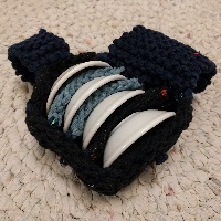 Four sake cups all arranged in a blue and dark blue cup cozy