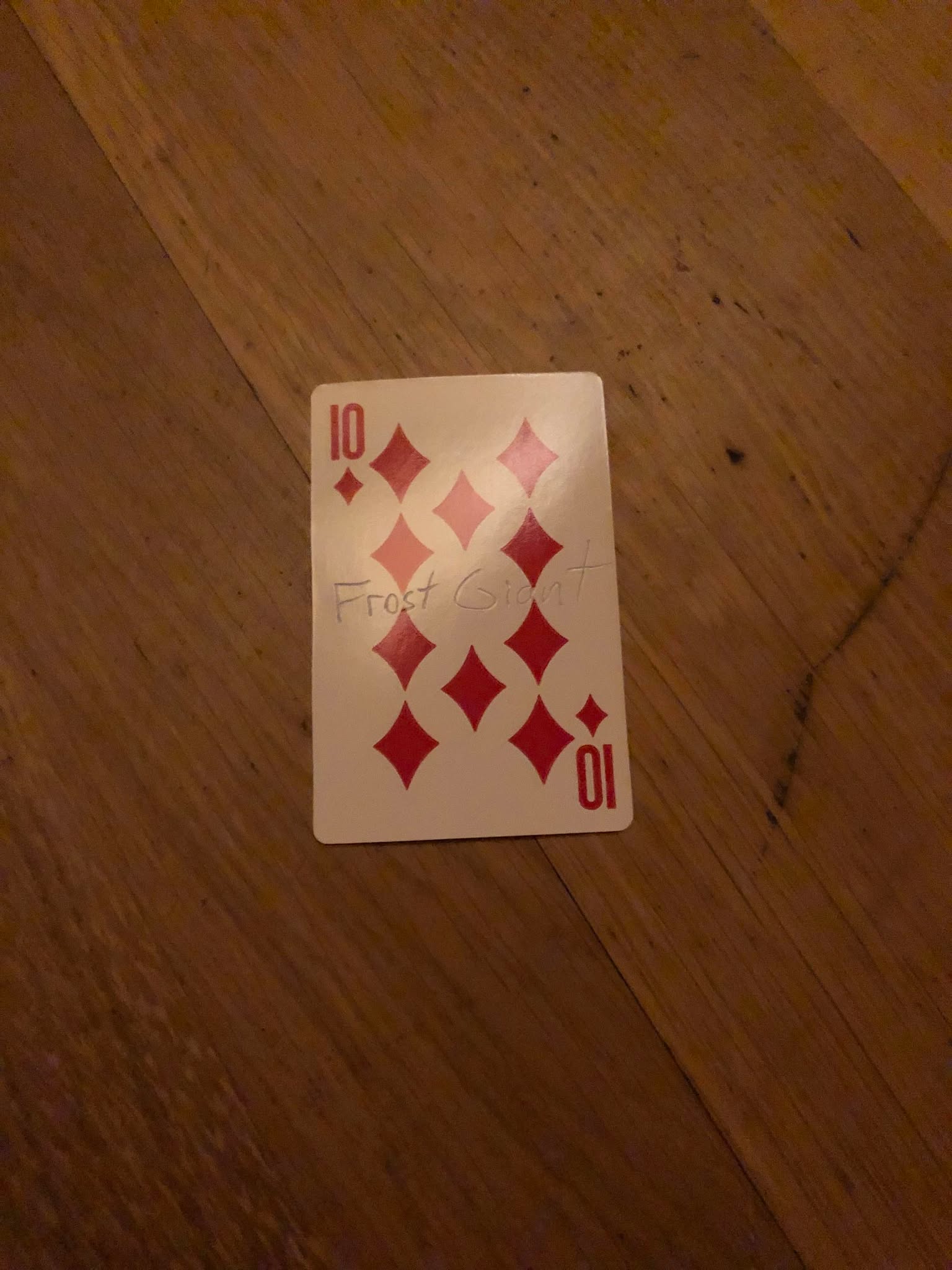The ten of diamonds, thrown to the floor in front of the creature.