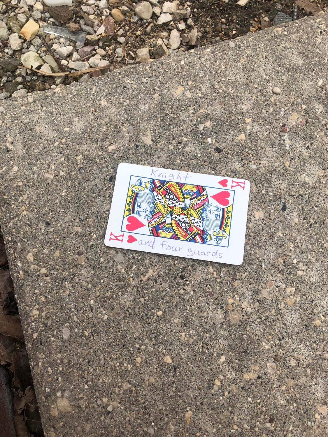 The king of hearts, laying on the ground before the creature.