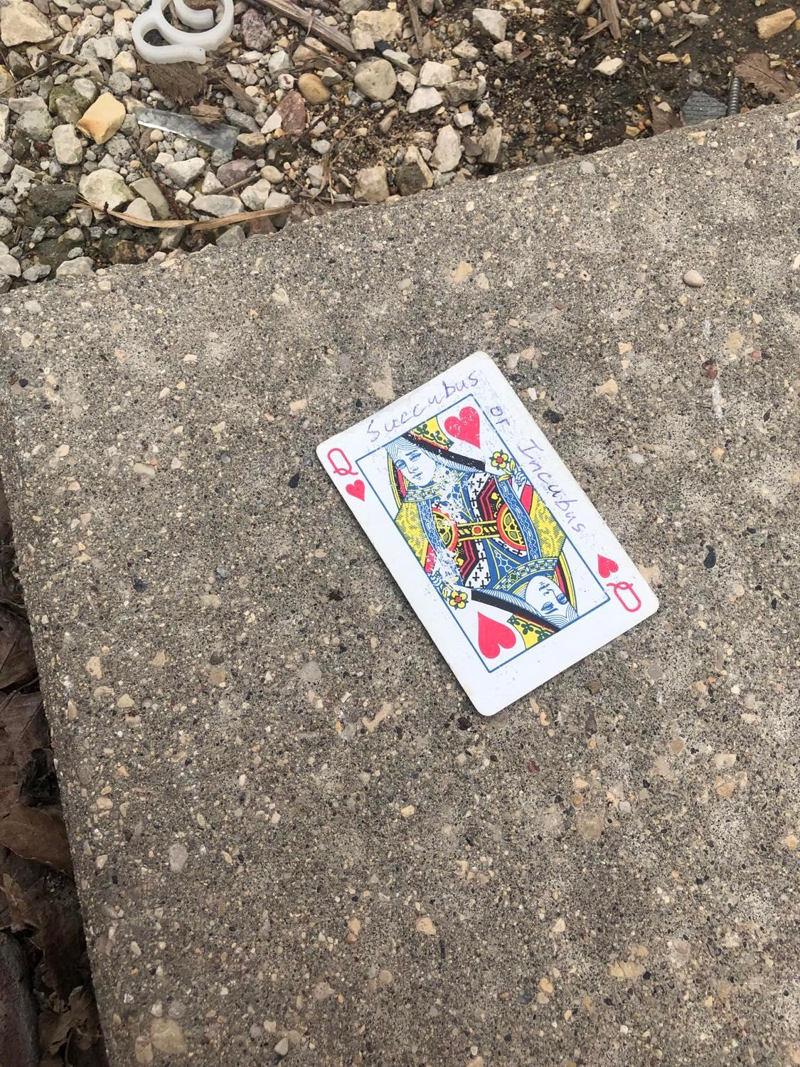The queenof hearts, laying on the ground before the creature.
