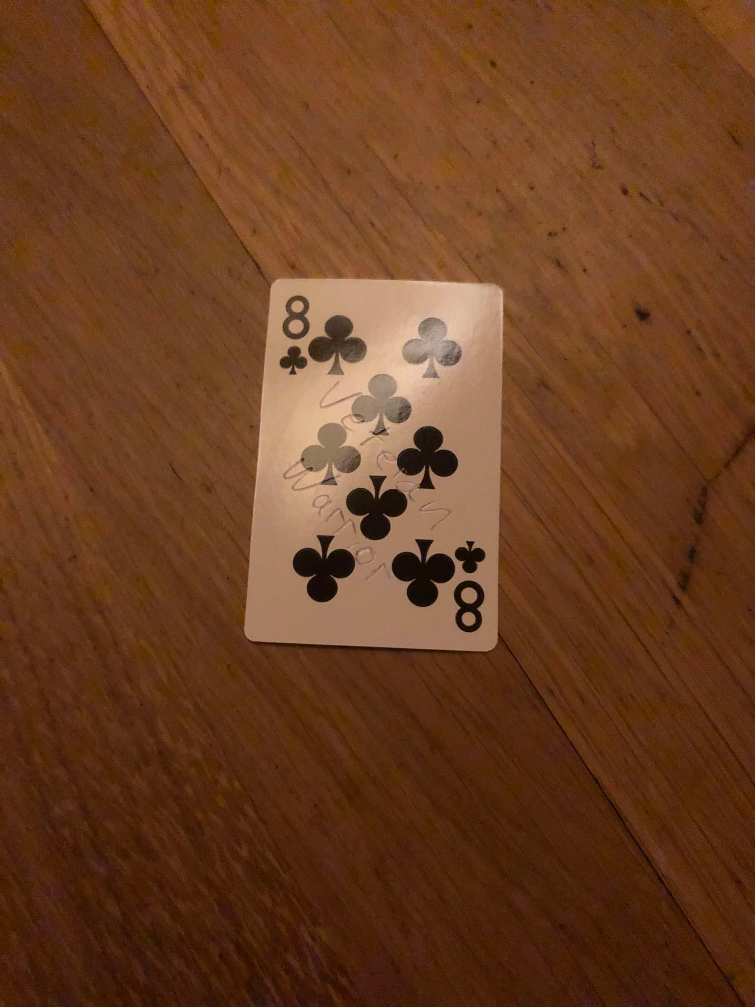 The eight of clubs, thrown to the floor in front of the creature.