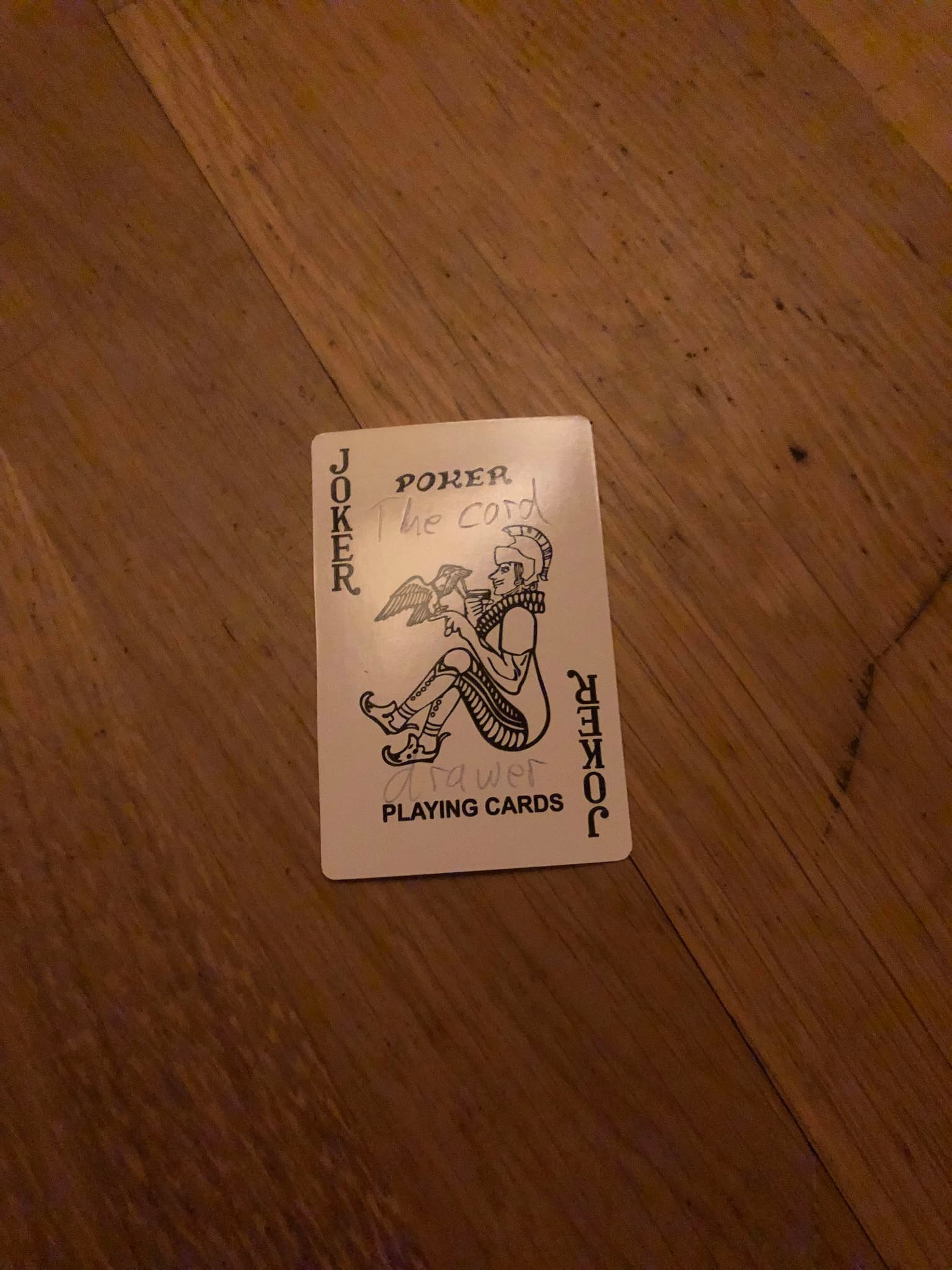 The joker, thrown to the floor in front of the creature.