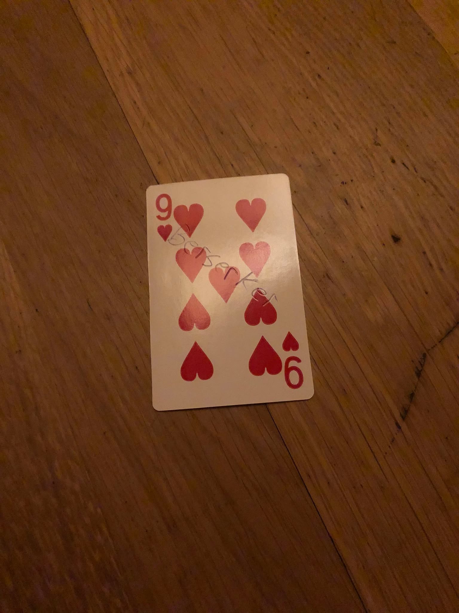 The nine of hearts, thrown to the floor in front of the creature.