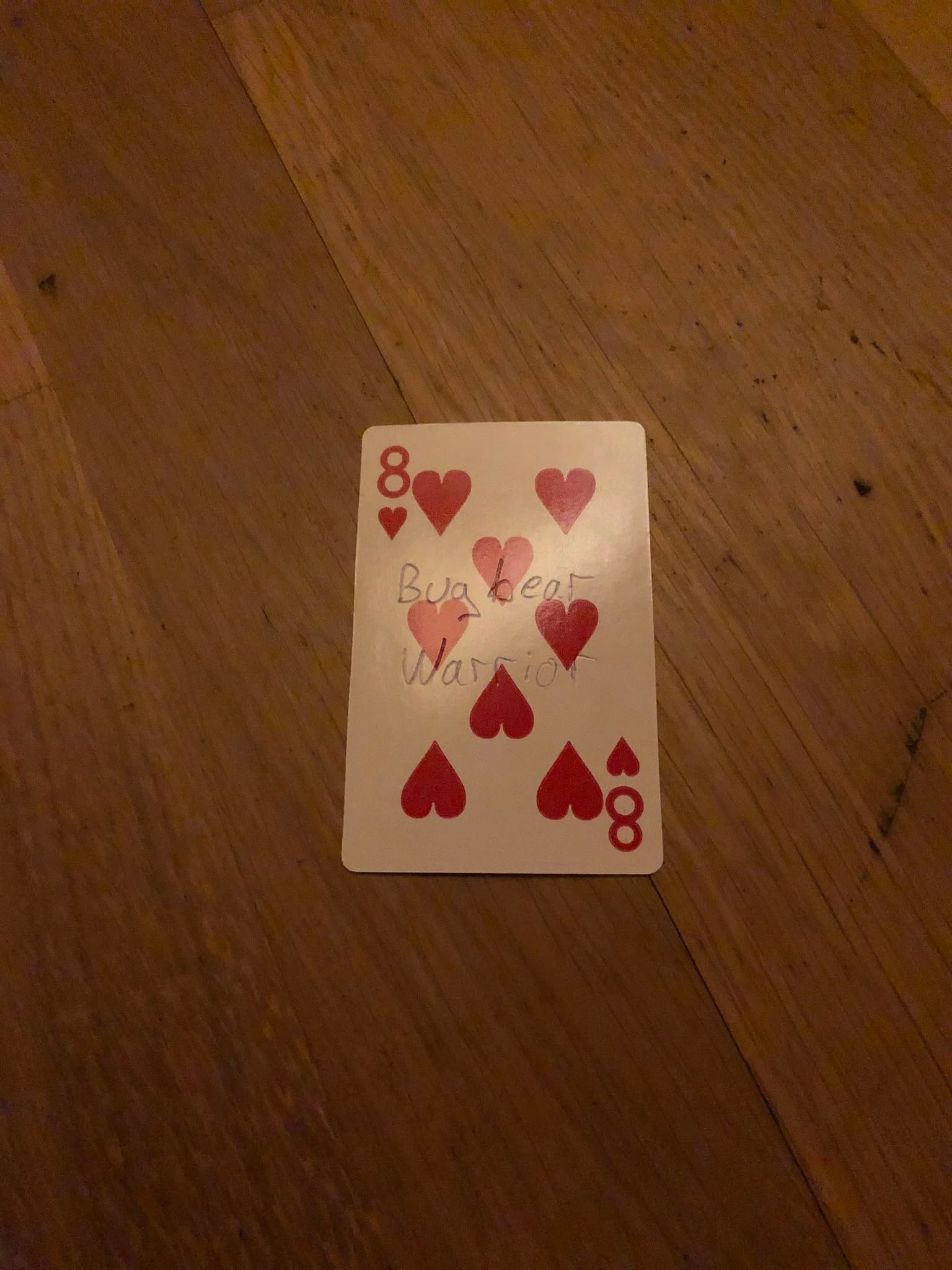 The eight of hearts, thrown to the floor in front of the creature.