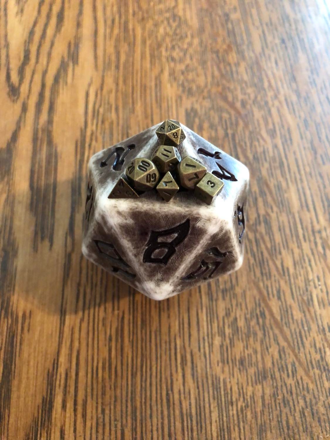 The seven micro dice all fitting on a single giant d20 face.