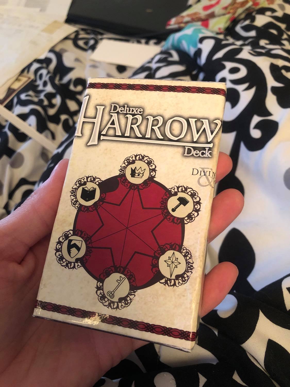 The original box modified to be one card width across. The text that says Deluxe Harrow Deck is still showing, with the logo centered in the middle