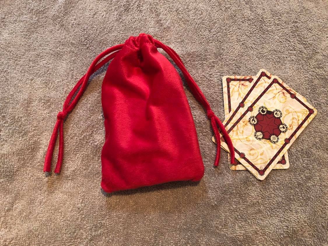 The completed bag and some of the tarot cards, on a beige towel.