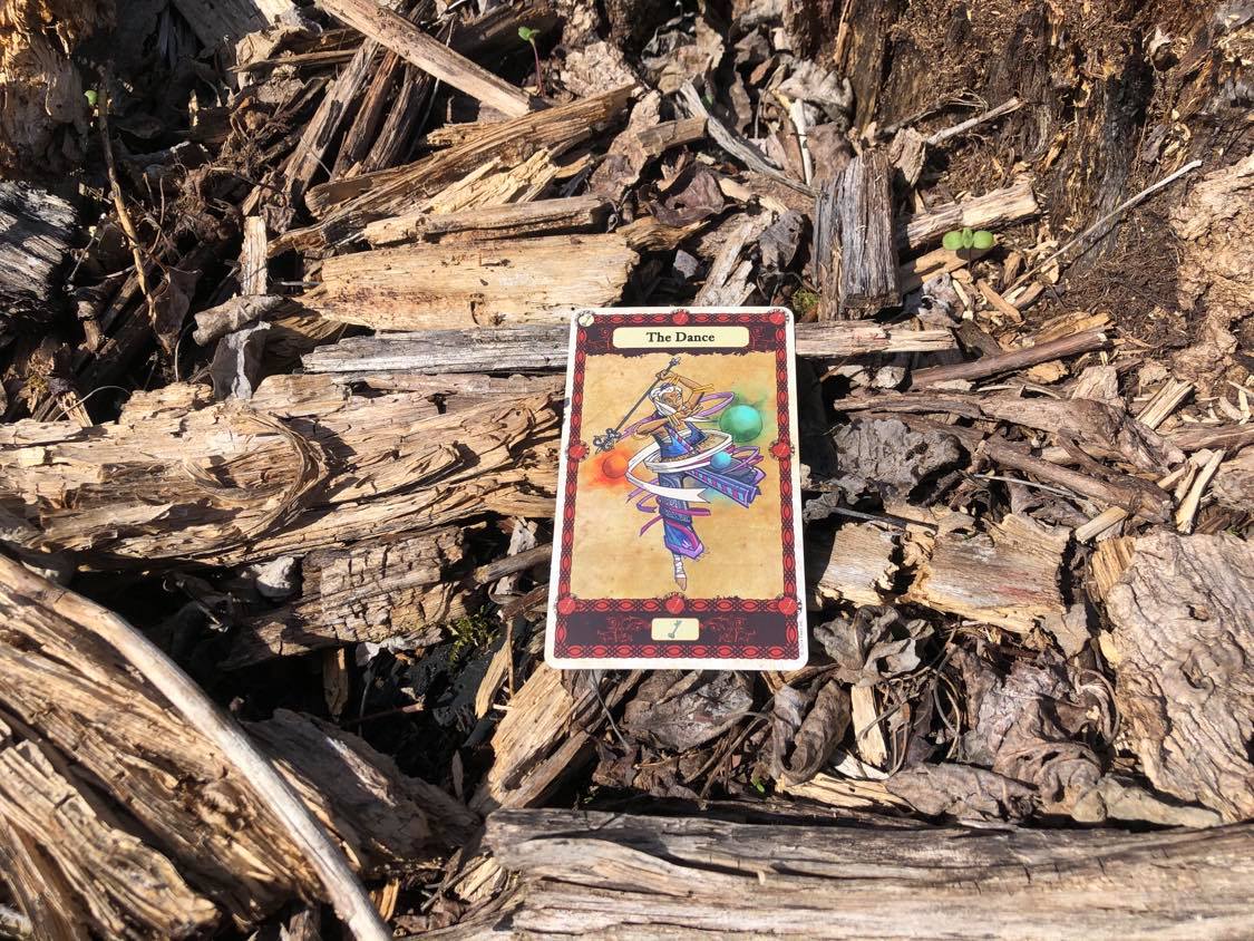 An elegant dancer, the card laying on the forest debris.