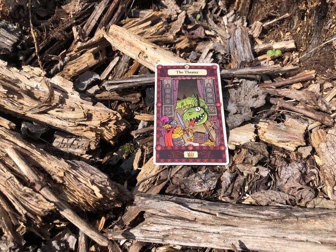 A warrior fighting a puppet snake, the card laying on the forest debris.