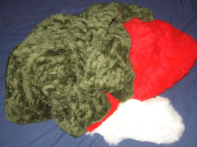 A pile of green and red and white furry fabric on top of a blue sheet.