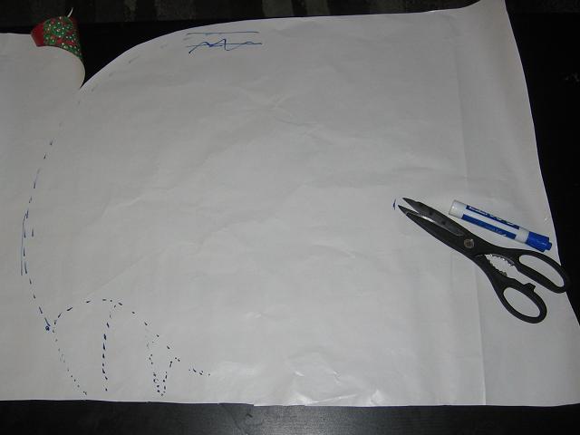 The stencil partially drawn onto the back of wrapping paper, ready to be folded in half for symmetry.