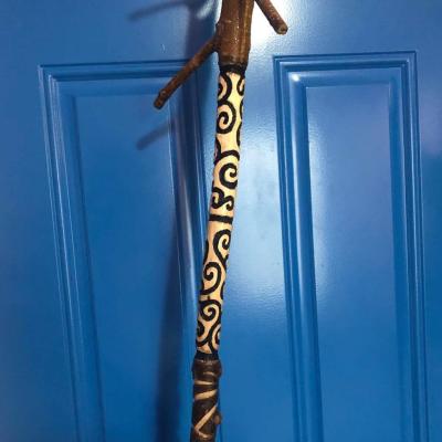 A photo of the handle portion of a staff with very swirly patterning on the grip. The staff itself is named The Twisted Sisters