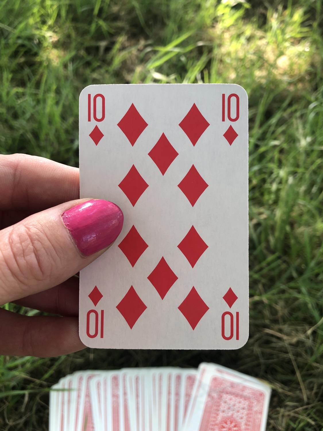 The ten of diamonds, held up from the drawn out cards.