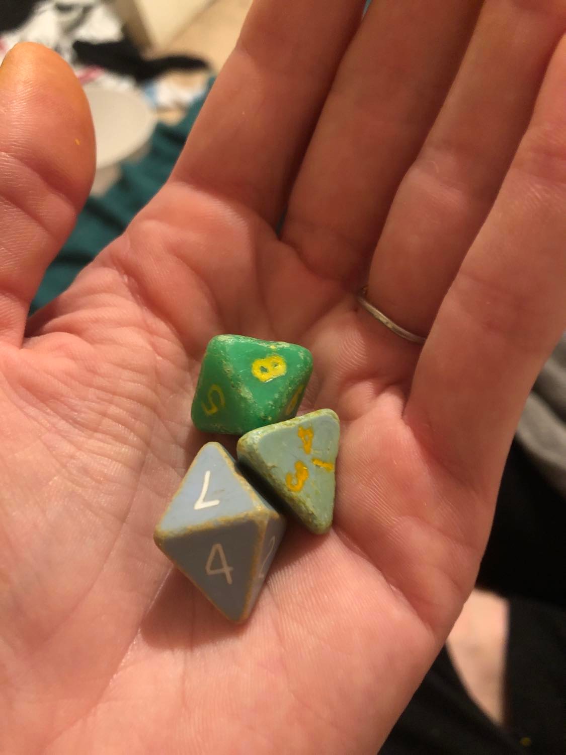 The three original dice, recoloured and sitting in Kabutroid's hand. The numbering on the Homes is now yellow, the Moldvay is orange, and the Mentzer has fresh white numbering.