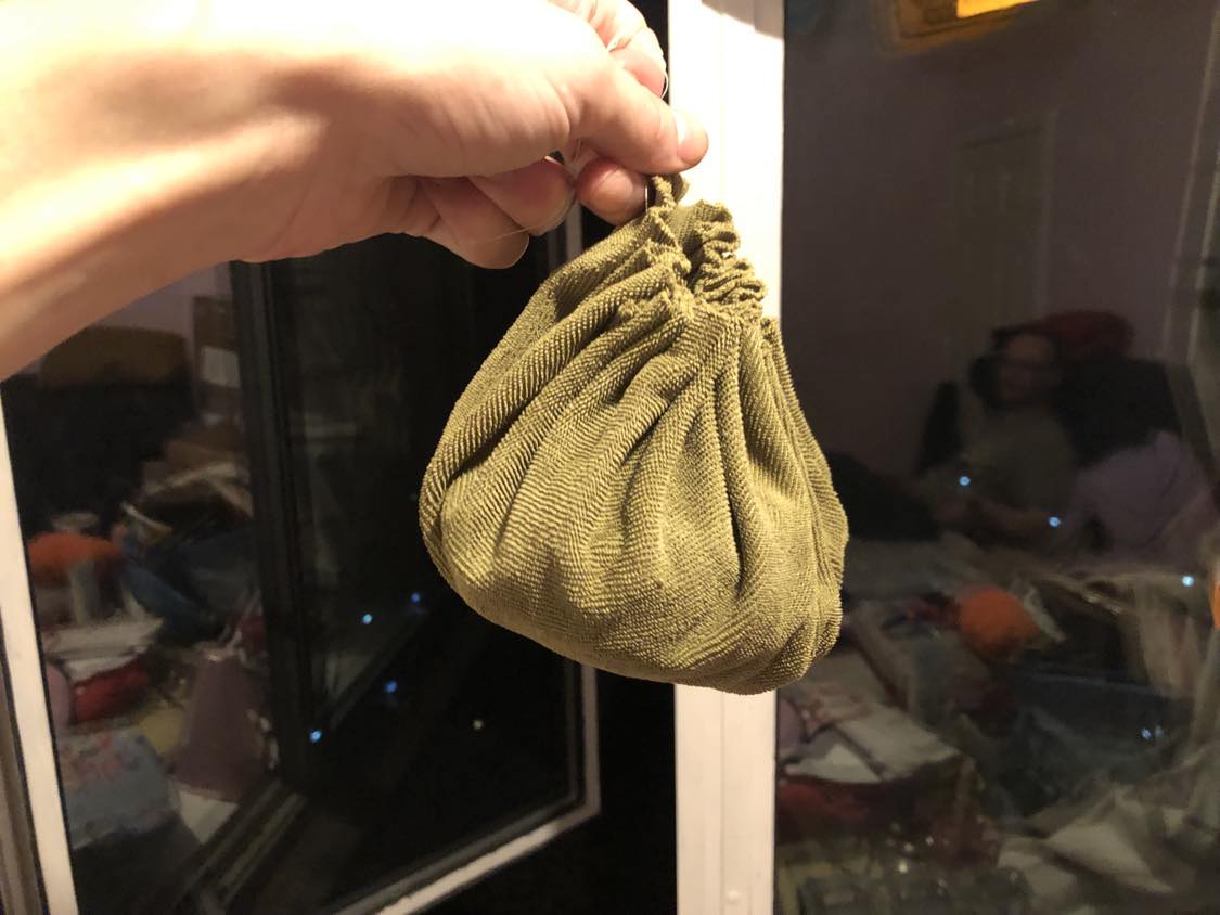 A putrid green pouch, being held in wait.